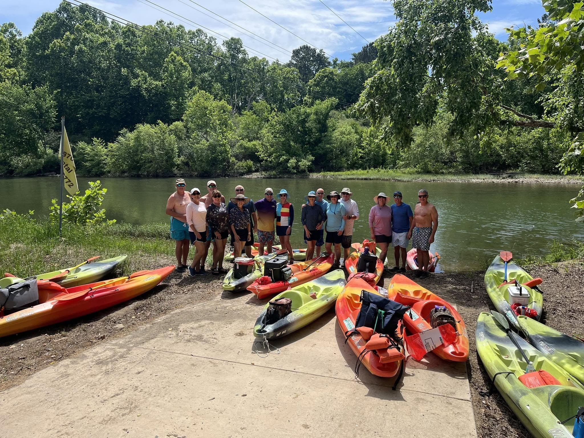 A group beside colorful kayaks on the Caddo River